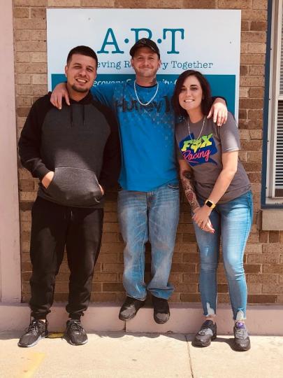 Individuals standing in front of a sign